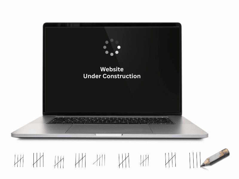 Picture of laptop screen with text: Website under construction. Next to it a pencil that has been used to mark the passing days on the desk.